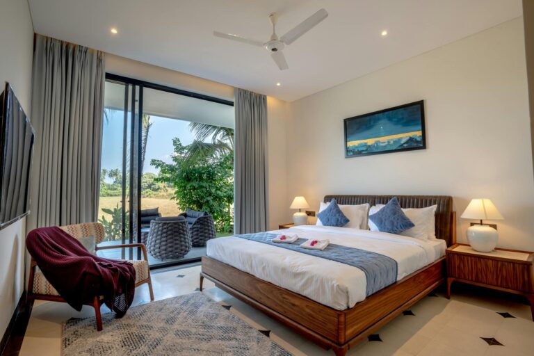 Elegant and luxurious bedroom in a Saligao villa with a scenic outdoor view, perfect for relaxation.