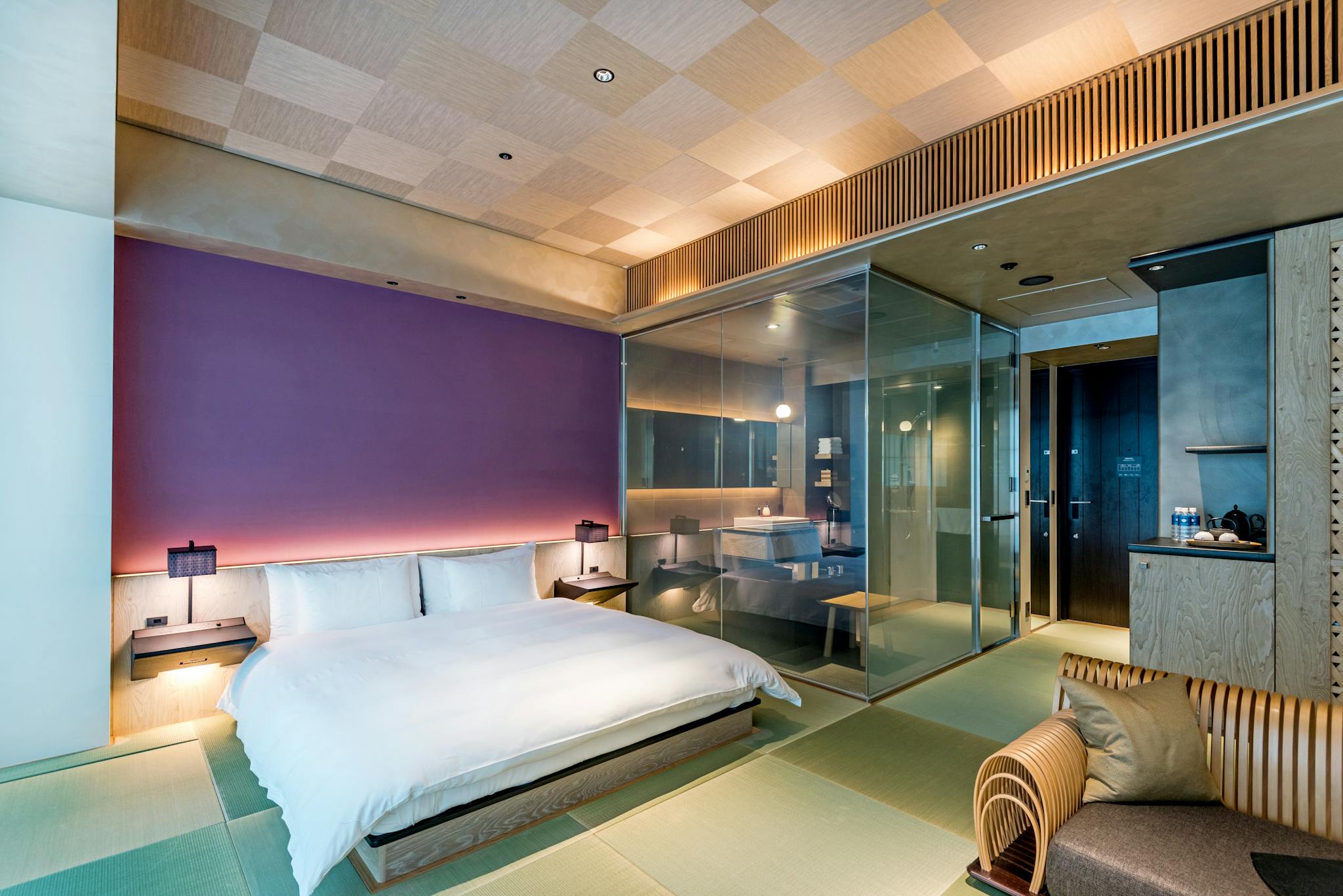 Spacious and luxurious bedroom featuring a glass wall design, blending modern aesthetics with comfort.